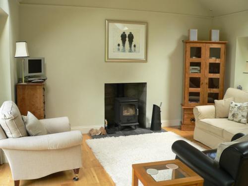 Cosy cottage for two in the highlands في Fortingall: غرفة معيشة مع أريكة ومدفأة