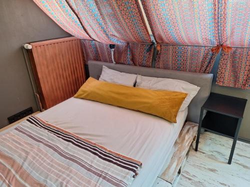 a bed with a yellow pillow on top of it at Charmante Fachwerkhaushälfte mit Sauna in Rosche