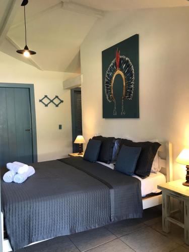 a bedroom with a bed and a picture on the wall at Pousada dos Pássaros Geribá in Búzios