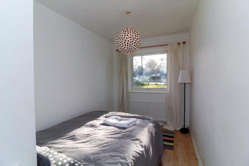 a bedroom with a bed and a window at Neat 2 bedroom ground floor flat in Beckenham