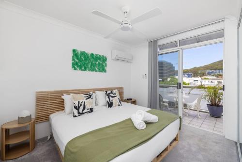 a bedroom with a large bed and a balcony at Nelson Towers- Overlooking The Bay in Nelson Bay