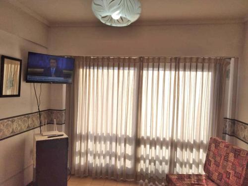 a living room with a large window and a television at Atlántico Peatonal in Necochea