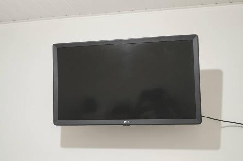 a flat screen tv hanging on a wall at ꕥ Suíte Deluxe Privativa ꕥ Cantinho da Margarida ꕥ Hospedagem & Hostel Premium in Belém