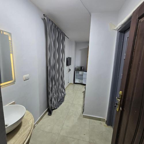 a hallway leading to a bathroom with a shower curtain at Cozy Private Studio DBL in ‘Ezbet `Abd el-Ḥamîd