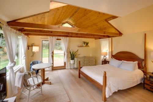 een slaapkamer met een groot bed en een tafel bij Pacific View Cottage - 100 High with Ocean Views in Langlois