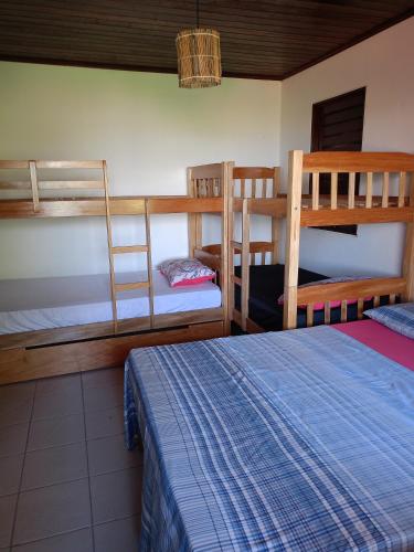 a bedroom with two bunk beds and a bed at CASA de 02 suítes e 1 quarto, piscina e churrasqueira "casa maré alta" in Barra de São Miguel