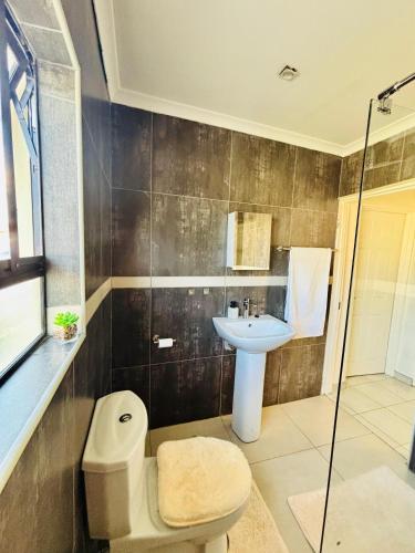 a bathroom with a toilet and a sink and a shower at Small town comfort in Marquard