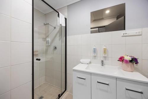 Cosmo on Bank في أديلايد: حمام أبيض مع حوض ودش