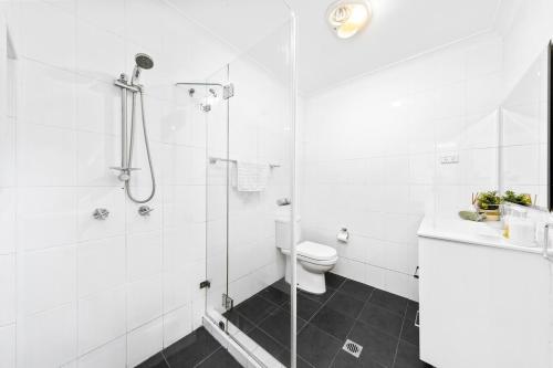 Un baño blanco con ducha y WC. en Charming Haven, peaceful stay, en Castle Hill