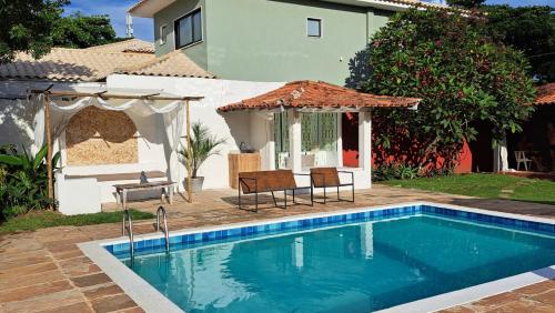 a swimming pool in front of a house at Pousada dos Pássaros Geribá in Búzios