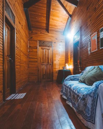 a bedroom with a bed and a wooden wall at Casa Aldirica in Cahuita
