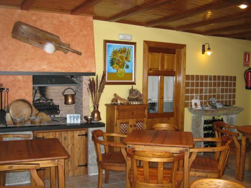 a kitchen and dining room with tables and a fireplace at Casa La Abadía in Cerler