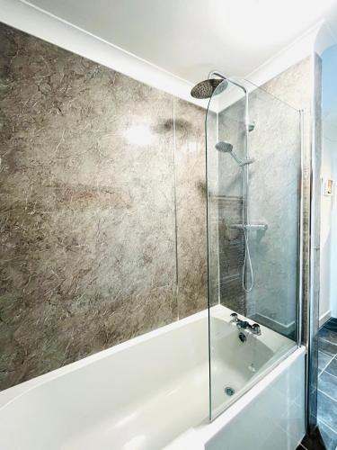 a bathroom with a shower and a bath tub at River house in Birnam