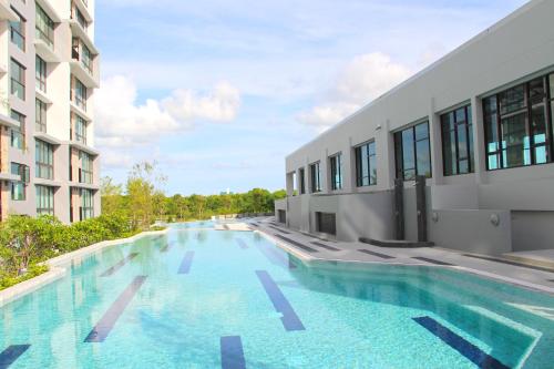 a large swimming pool next to a building at Connext Residence in Phuket