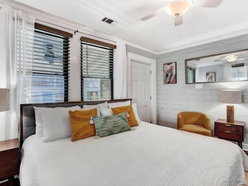 una camera da letto con un letto, una sedia e finestre di Ebb & Flow Apartment House a Tybee Island