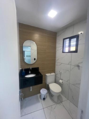 a bathroom with a toilet and a sink and a mirror at Apto aconchegante na Boa Vista - 2 Quartos - Perto Consulado in Recife
