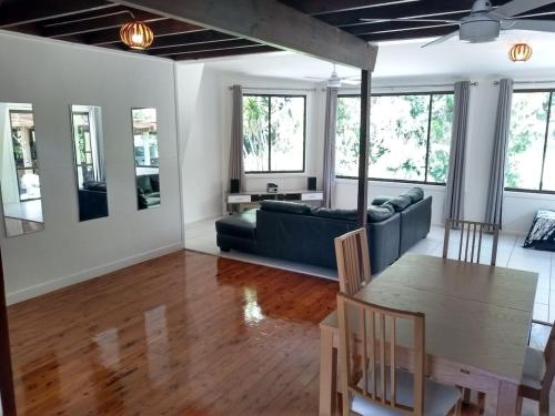 a living room with a couch and a table at Iluka Rainforest Beach Shack Eco-Home in Woombah