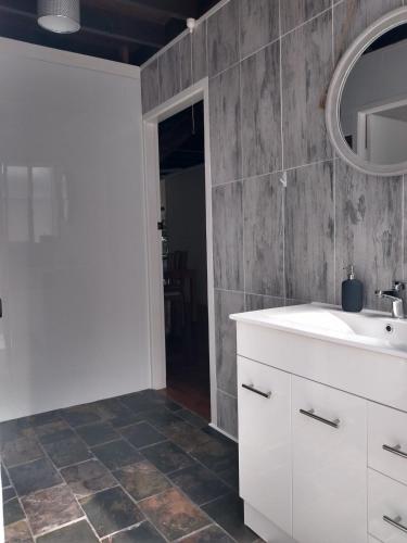 a bathroom with a sink and a mirror at Iluka Rainforest Beach Shack Eco-Home in Woombah