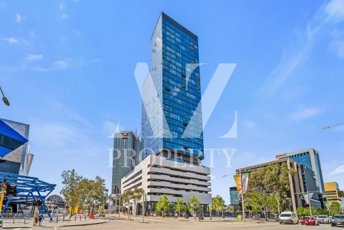 a tall glass building in a city with buildings at Luxury Perth Apartment - City Views RAC Arena Pool & Gym in Perth