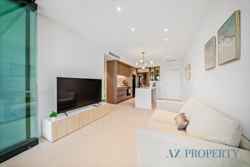 a living room with a couch and a tv at Luxury Perth Apartment - City Views RAC Arena Pool & Gym in Perth
