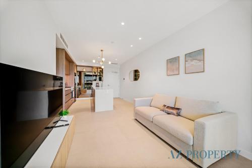 a living room with a couch and a tv at Luxury Perth Apartment - City Views RAC Arena Pool & Gym in Perth