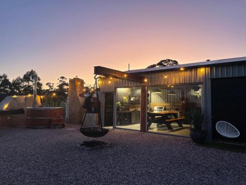 a person standing in front of a house with windows at Humbug Bunk House & Hot Tub! in St Helens