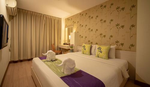 twee opgezette olifanten zitten op twee bedden in een hotelkamer bij Taradii Boutique -Villa Cha-Cha Khoasan Rambuttri in Bangkok