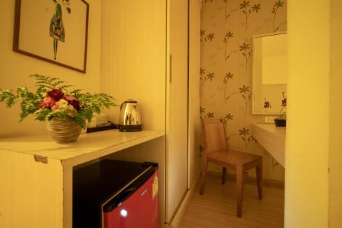 een kamer met een tafel met een vaas met bloemen bij Taradii Boutique -Villa Cha-Cha Khoasan Rambuttri in Bangkok