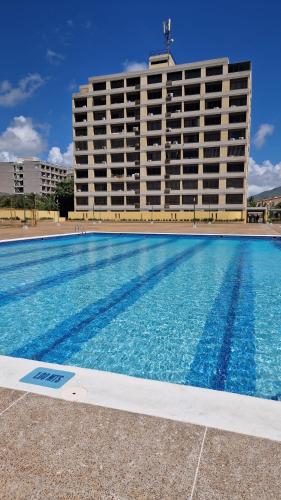 a large swimming pool in front of a hotel at Apartamento Isla de Margarita in Pampatar
