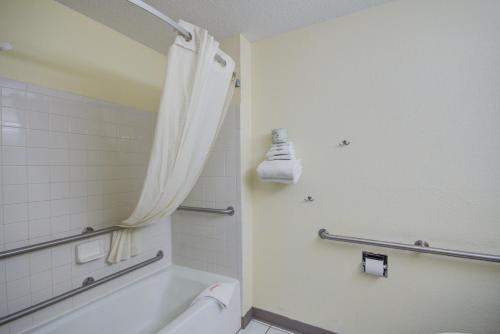 a bathroom with a tub and a toilet and a shower at Super 8 by Wyndham Zanesville in Zanesville