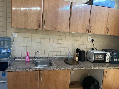 a kitchen counter with a sink and a microwave at ALFUTTAIN Vacation Homes Rental in Dubai