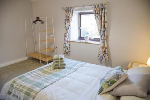 a bedroom with a bed and a window at Little Thornsett in Buxton