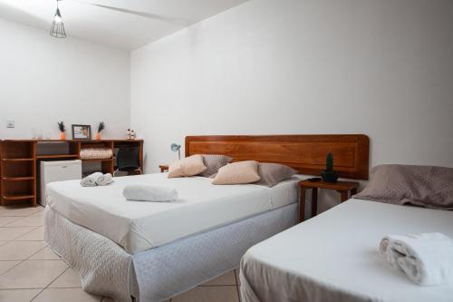 Dos camas en una habitación con paredes blancas. en Ilha Náutica, en Florianópolis