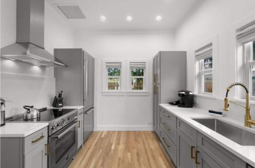 uma cozinha com balcões brancos e aparelhos de aço inoxidável em NEW Casa Padron & La Casita em Tampa