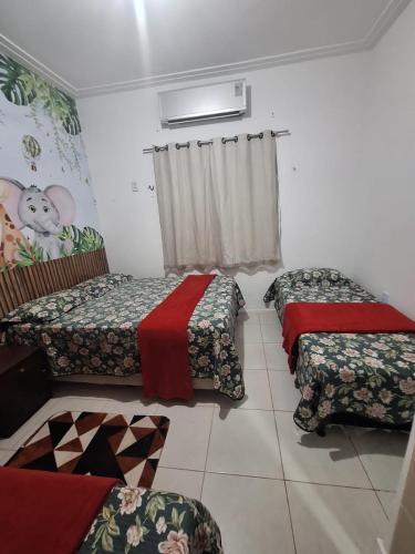 um quarto com três camas e uma janela em Casa de 3 quartos com Piscina 2km da Praia Araçagy em São Luís