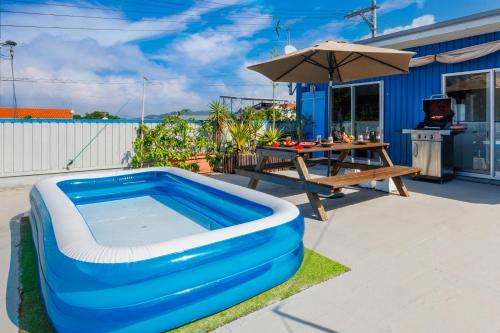 a large inflatable swimming pool sitting next to a picnic table at 瀬底Dcottage本部町で完全プライベートでBBQ可能 in Sesoko