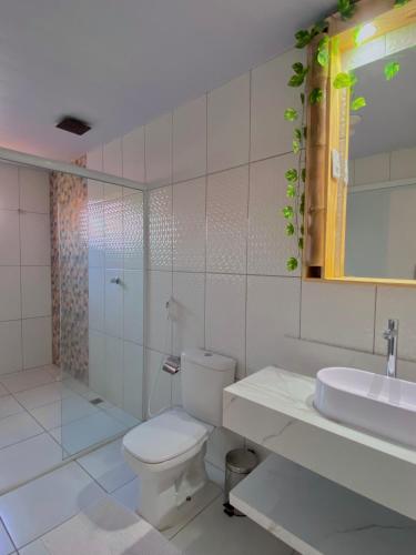 a white bathroom with a toilet and a sink at Lar dos Lençóis in Barreirinhas
