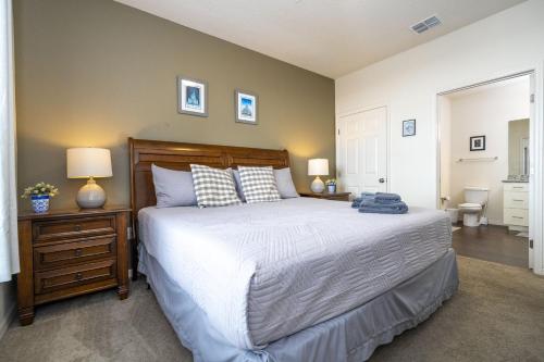 a bedroom with a bed and a nightstand with two lamps at Villa Hakuna Matata- Lucaya Village Resort in Kissimmee