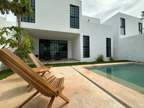 a pair of chairs sitting next to a swimming pool at Private Canarian house with pool in Conkal