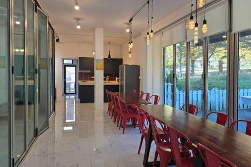 a large dining room with a long table and red chairs at Paju Gallery Café Pension Soon in Paju