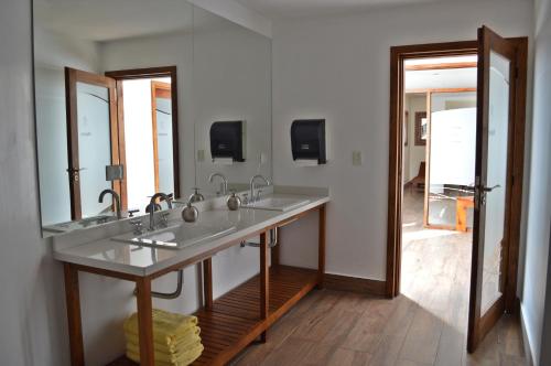 La salle de bains est pourvue de 2 lavabos et d'un grand miroir. dans l'établissement Paihuen - Resort De Montaña, à San Martín de los Andes