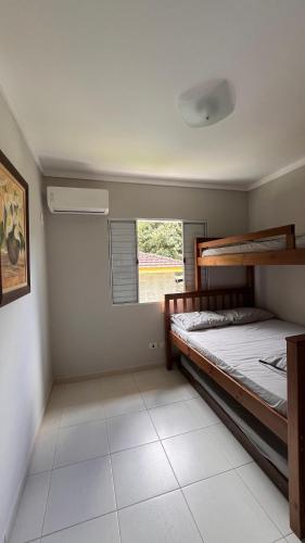 een slaapkamer met een stapelbed en een raam bij Toque Toque Grande Paraiso in Sao Paulo