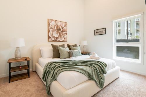 a white bedroom with a bed and a window at The Village Collection with Gym Pool and Spa in Montclair
