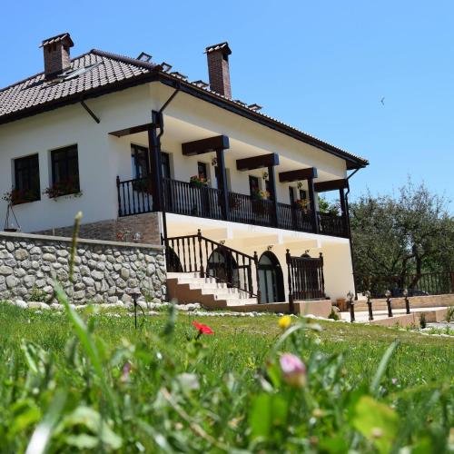 a large white house with a stone wall at Pensiunea Agroturistica Cerna, Vaideeni - Polovragi in Vaideeni