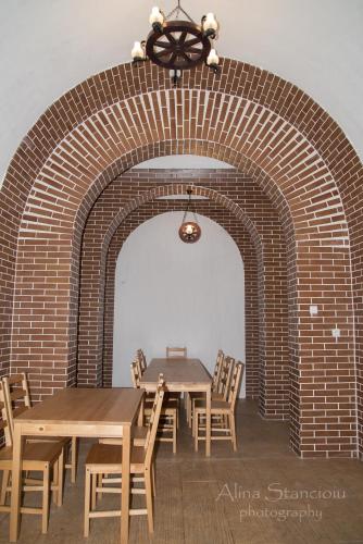 a dining room with two tables and a brick wall at Pensiunea Agroturistica Cerna, Vaideeni - Polovragi in Vaideeni