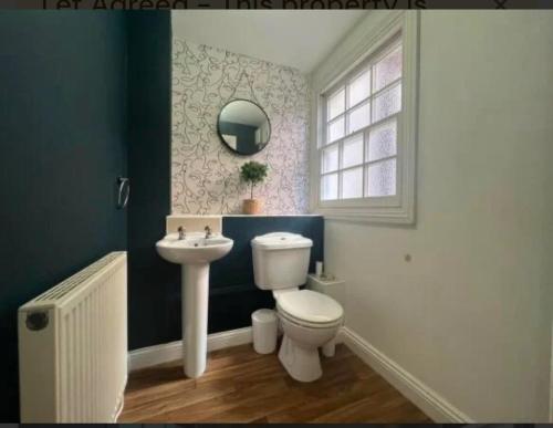 a bathroom with a toilet and a sink and a window at Two bed town house in Royal Leamington Spa in Leamington Spa