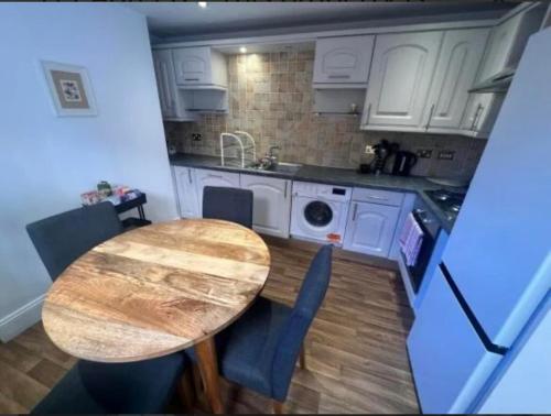 a kitchen with a wooden table and a kitchen with white cabinets at Two bed town house in Royal Leamington Spa in Leamington Spa