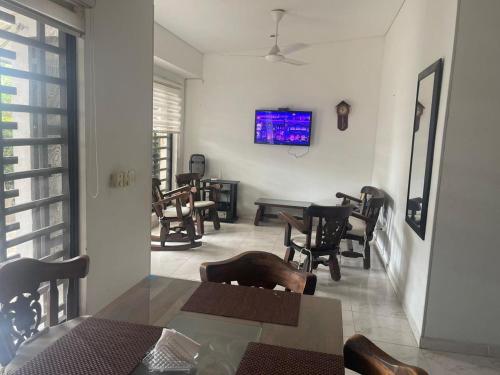 a dining room with a table and chairs and a tv at CASA EN FLANDES A 10 MIN DE GIRARDOT in Flandes