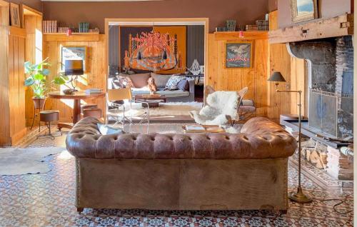 ein Ledersofa im Wohnzimmer mit Kamin in der Unterkunft 3 Bedroom Gorgeous Home In Arjuzanx in Arjuzanx