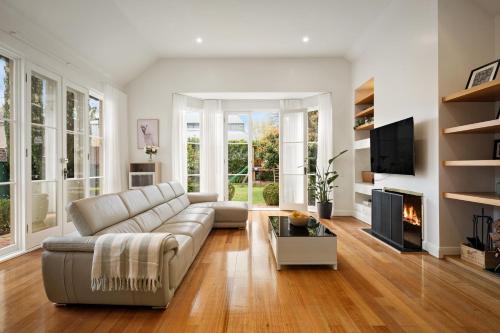 a living room with a couch and a fireplace at Charming Red Brick Estate in Kew 5BR & Playhouse in Melbourne